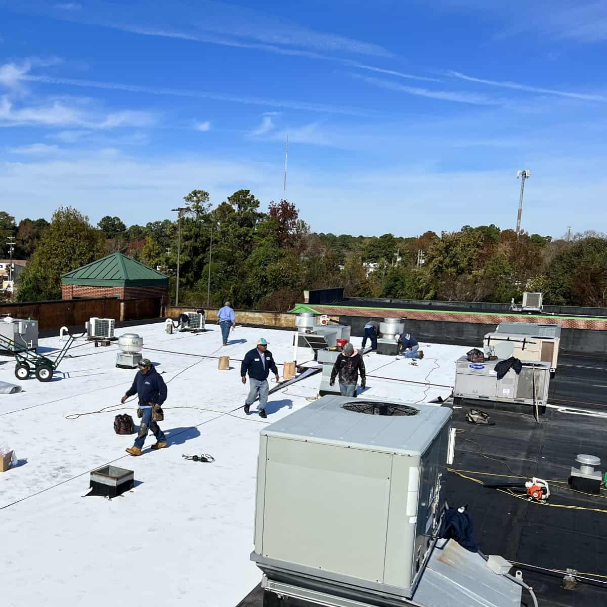 commercial roofers repairing a flat roof