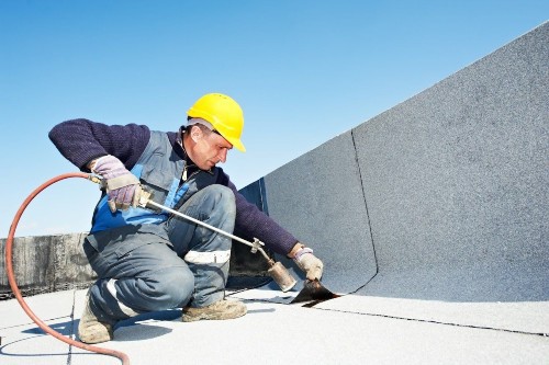 Flat Roof Specialist — Worker Repairing Flat Roof in Raleigh, NC
